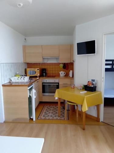 une petite cuisine avec une table et une nappe jaune dans l'établissement Appartement 6 personnes Gruissan, à Gruissan