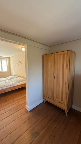 a bedroom with a bed and a wooden cabinet at Ferienhaus St. Johannis in Werben