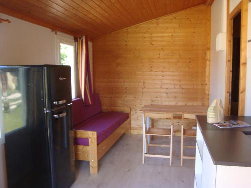 Il comprend une petite cuisine avec un canapé, une table et un réfrigérateur. dans l'établissement La Pourvoirie des Ellandes, à Excenevex