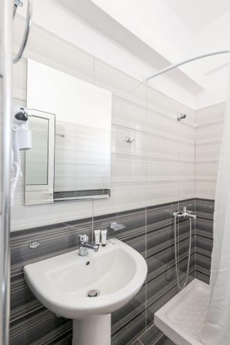 a bathroom with a sink and a mirror at Aleksander ApartHotel in Ksamil