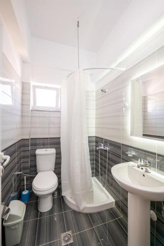 a bathroom with a toilet and a sink and a shower at Aleksander ApartHotel in Ksamil