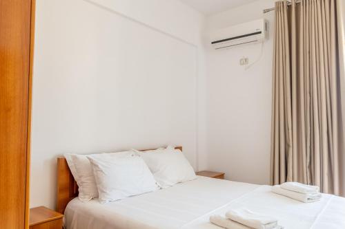 a bedroom with a white bed and a air conditioner at Aleksander ApartHotel in Ksamil