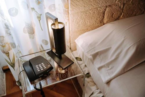 a phone on a glass table next to a bed at Santa Rosa Relais in Noci