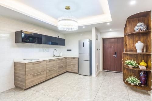 a kitchen with a refrigerator and wooden cabinets at 重庆乐隐江景民宿 in Chongqing