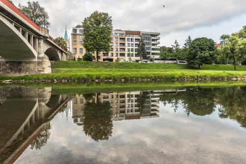 a reflection of a building in a body of water at Apartament Bulwary 36 in Oświęcim