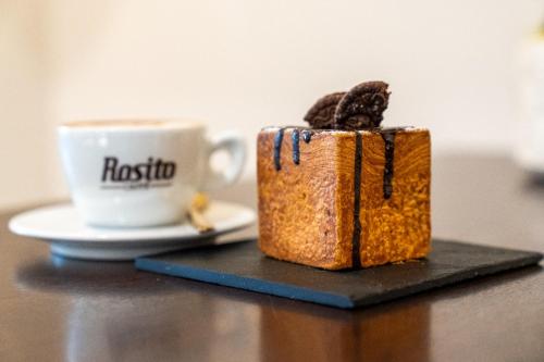 a cup of coffee and a piece of bread next to a table at Edward Rooms & Wellness B&B in Trani