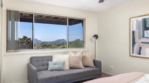 a living room with a couch and a large window at Hamptons By The Bay in Nelson Bay