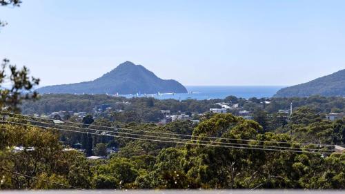 a view of a town with a mountain in the distance at Hamptons By The Bay in Nelson Bay