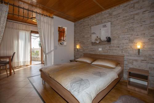 a bedroom with a large bed and a brick wall at Apartments Villa Salona in Opatija
