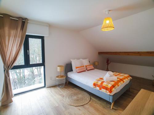 une chambre avec un lit et une grande fenêtre dans l'établissement Chez Tonton, à La Muraz