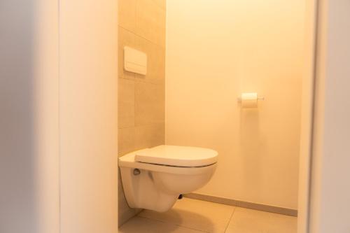 a bathroom with a white toilet in a stall at Appartement Cosy près de tout ! in Mons