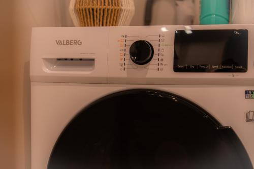 a white washing machine with a window on it at Appartement Cosy près de tout ! in Mons