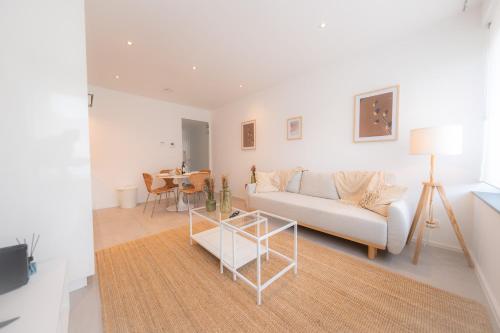 a living room with a couch and a table at Appartement Cosy près de tout ! in Mons