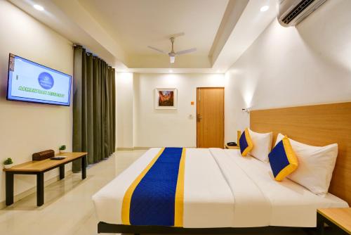 a hotel room with a bed and a tv at Aamantran Residency Hotel, Sohna Road, Sector 49, Gurugram in Gurgaon