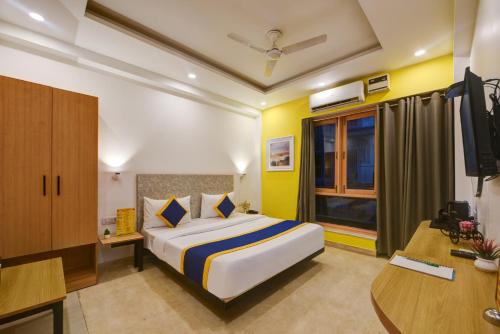a hotel room with a bed and a desk at Aamantran Residency Hotel, Sohna Road, Sector 49, Gurugram in Gurgaon