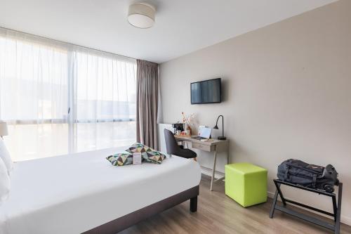 a bedroom with a bed and a desk and a window at Appart’City Confort Rennes – Cesson Sévigné in Cesson-Sévigné