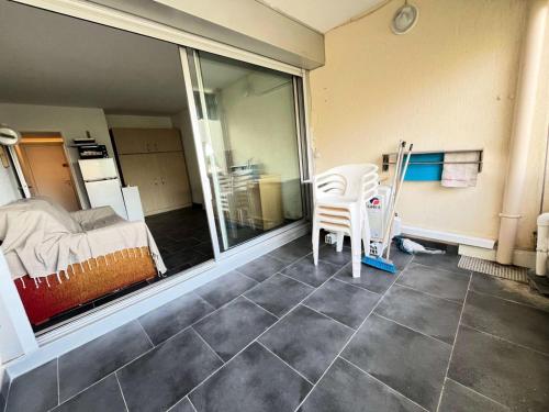 Cette chambre comprend une chambre, un lit et une chaise. dans l'établissement Résidence Quai Aux Fleurs - Studio 4 couchages avec piscine MAE-5391, au Grau-du-Roi