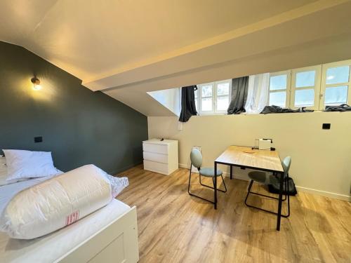 - une chambre avec un lit et un bureau avec une table dans l'établissement Studio cosy avec salle de sport, à Saint-Étienne