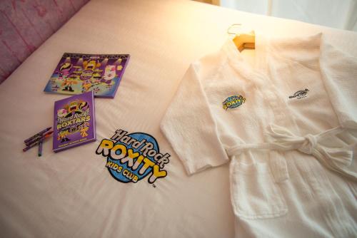 a white shirt with various stickers on a bed at Hard Rock Hotel Penang in Batu Ferringhi
