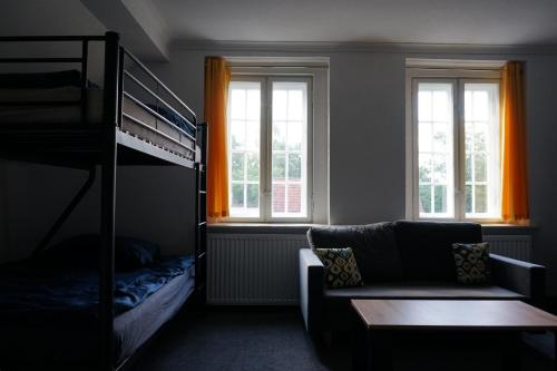 a bedroom with a couch and a bunk bed at Hotel Krasnoludki in Sosnówka