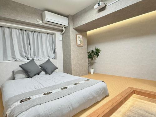 a bedroom with a large bed and a window at 桜南大塚ハウスii in Tokyo