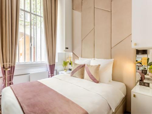 une chambre avec un grand lit blanc avec une fenêtre dans l'établissement Merveil - Luxury Suite - Marais - Archives I, à Paris