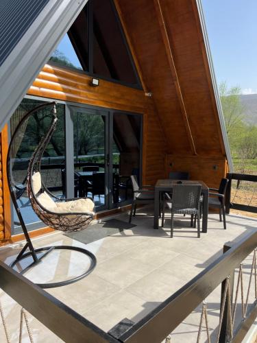 a porch with a swing and chairs on a house at Vila Jezero-Jajce in Jezero