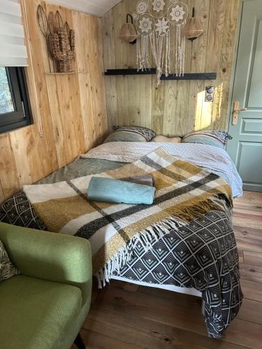 - une chambre avec un lit, une couverture et une chaise dans l'établissement ROULOTTE VAR MER & MONTAGNE, au Luc