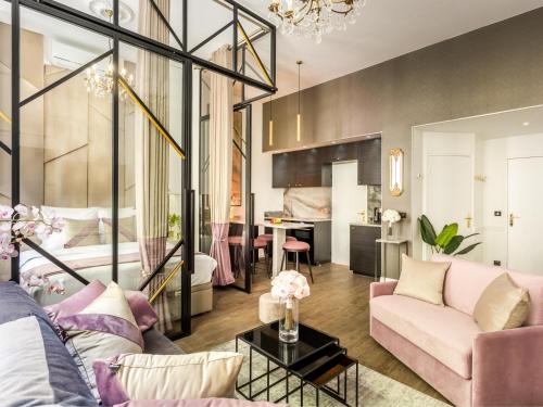 un salon avec un canapé rose et une chambre dans l'établissement Merveil - Luxury Suite - Marais - Archives I, à Paris