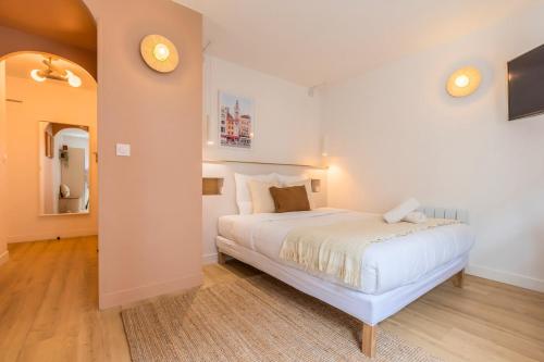 une chambre avec un lit blanc dans une pièce dans l'établissement Petit studio proche écoles & commodités, à Lille