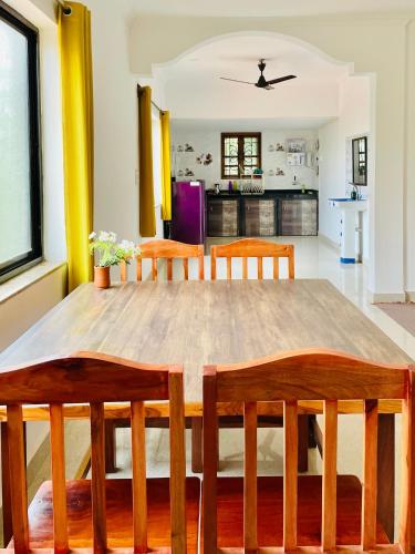 a dining room with a wooden table and chairs at Aamra Ghar by evaddo in Mandrem