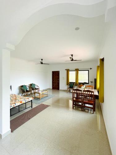 a large white room with a table and chairs at Aamra Ghar by evaddo in Mandrem