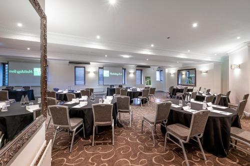 a banquet room with tables and chairs in a building at Holiday Inn - Manchester - Oldham by IHG in Manchester