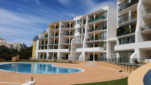 un edificio de apartamentos con piscina frente a él en Primavera Sun, en Portimão