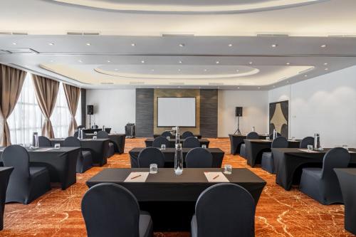 a conference room with tables and chairs and a screen at Lexis Hibiscus Port Dickson in Port Dickson