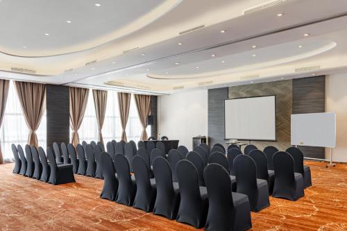 a conference room with chairs and a screen at Lexis Hibiscus Port Dickson in Port Dickson
