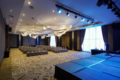 a banquet hall with white chairs and a stage at Lexis Hibiscus Port Dickson in Port Dickson