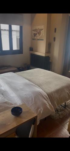 a bedroom with a bed and a wooden table at Hotel Maistra in Tsagarada