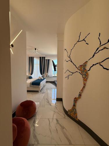 a living room with a wall mural of a tree at Positano Art Hotel Pasitea in Positano