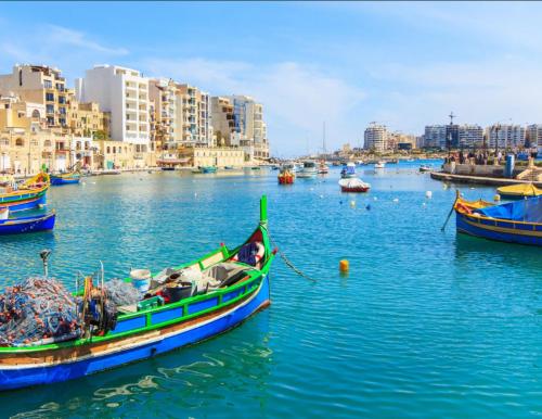 a group of boats in a body of water with buildings at La Bella Guesthouse in St Julian's
