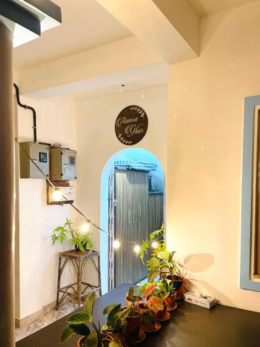 a room with a door and a table with plants at Aamra Ghar by evaddo in Mandrem