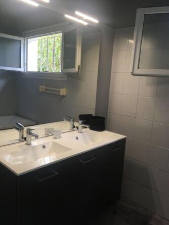 une salle de bain avec un lavabo blanc et un miroir dans l'établissement Mayotte, à Biscarrosse