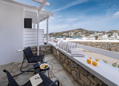 a balcony of a house with chairs and a table at Deliades Hotel in Ornos