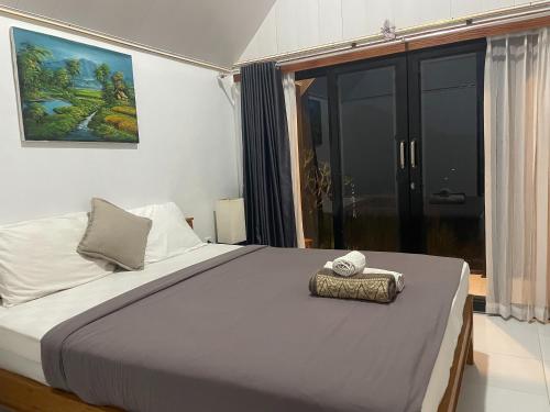 a bedroom with a large bed with a towel on it at The Iris Kintamani in Kubupenlokan