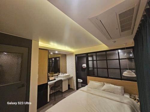 una camera da letto con un letto e un bagno con un lavandino di 호텔라찌 a Busan