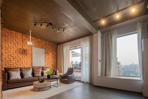 a living room with a couch and a brick wall at 重庆乐隐江景民宿 in Chongqing