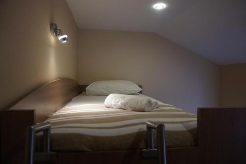 a bed with a white pillow on it in a room at Rooms and Apartment Soča Kobarid in Kobarid
