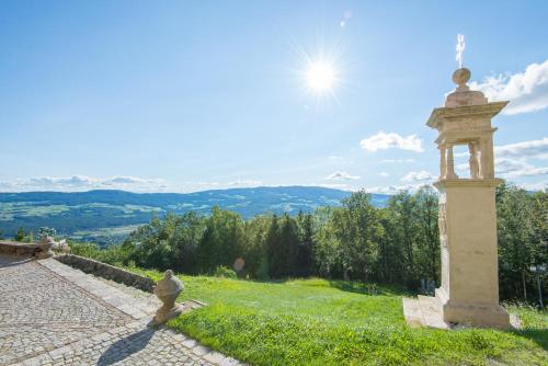 a stone pillar on a grassy hill with a view at Ferienwohnung in ruhiger Lage- Panorama Terrasse, 2 SZ, rollstuhlfreundlich in Pöllauberg