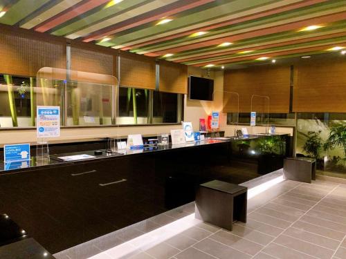 a kitchen with a counter with two stools at Dormy Inn Premium Namba Natural Hot Spring in Osaka