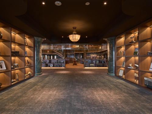 a large room with a library with shelves of shoes at Mission Hills Hotel in Minano